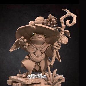 May include: A detailed, tan-colored figurine of a frog-like character wearing a large hat and cloak, holding a staff. The figure stands on a wooden platform with grass and the words "Bite the Bullet" are visible.