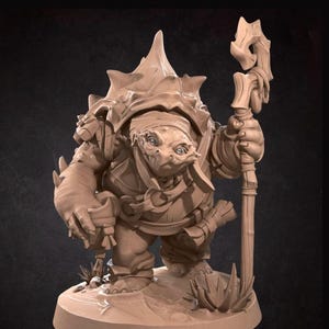 May include: A detailed figurine of a turtle-like creature, holding a staff and a small tool. The figure is in a standing pose, with a textured shell and clothing. The base has small plants and the text "BITE THE BULLET".