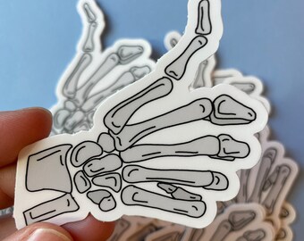 Pegatina de esqueleto con pulgar hacia arriba