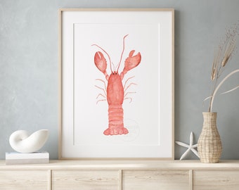 May include: A framed wall art print featuring a watercolor illustration of a red lobster centered on a white background. The lobster is depicted with two large claws, long antennae, and a segmented tail, rendered in soft shades of coral and pink.