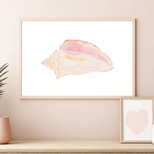 May include: A watercolor painting of a seashell in shades of pink and beige, framed in a light wood frame. The painting is displayed on a shelf with two potted plants.
