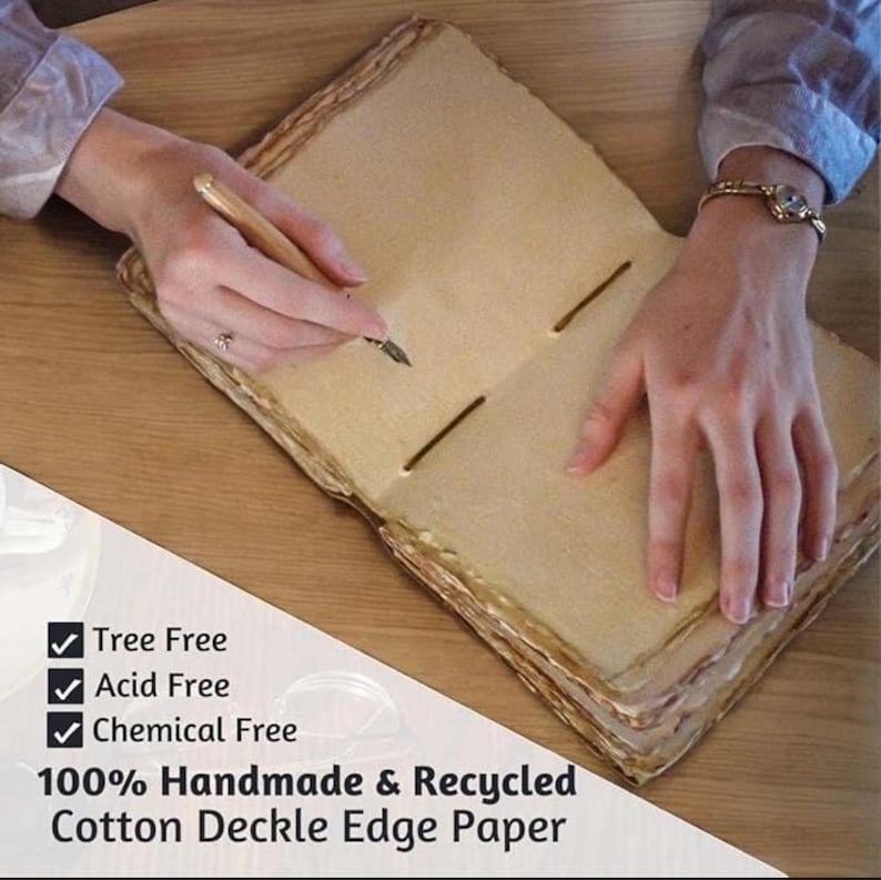 May include: Open handmade journal with deckle edges, being written on with a pen. The paper is a light tan color, and the journal is bound with twine. Text on the image reads: Tree Free, Acid Free, Chemical Free, 100% Handmade & Recycled Cotton Deckle Edge Paper.