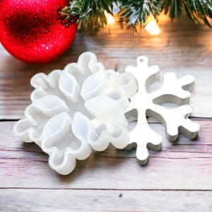 Peut inclure: Deux moules en silicone blancs en forme de flocon de neige pour la fabrication d'artisanat en résine. Un moule est un motif de flocon de neige détaillé, et l'autre est un flocon de neige avec six sections individuelles.
