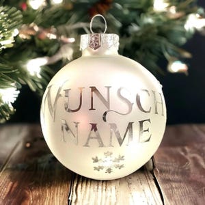 Personalized white frosted or shiny Christmas tree ornaments with custom name in festiv silver letters, personalised name gift bauble