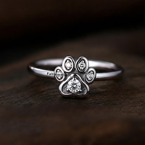 Op de afbeelding: Een zilveren ring met een pootprintontwerp met vijf heldere zirkonia-stenen.