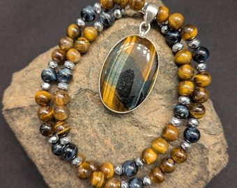 Colgante de plata 925 con ojo de tigre amarillo y azul. El collar está hecho de ojo de tigre amarillo, ojo de halcón y hematita plateada.