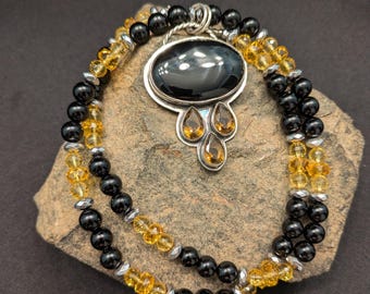 Colgante de plata 925 con ónix negro y topacio color miel. El collar es de ónix negro, citrino y hematita plateada.