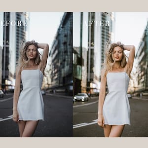 Peut inclure: Une femme en robe blanche se tient au milieu d'une rue de la ville. Les b&acirc;timents derri&egrave;re elle sont hauts et modernes. Ses cheveux sont balay&eacute;s par le vent.