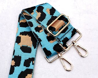 May include: A blue and black leopard print adjustable strap with gold metal hardware. The strap has two swivel clasps.