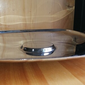 May include: A silver serving tray with a raised center and two dark red wooden handles.