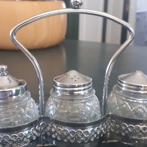 Salz-, Pfeffer- und Gewürzdosen aus Pressglas in einem Aluminiumkorb