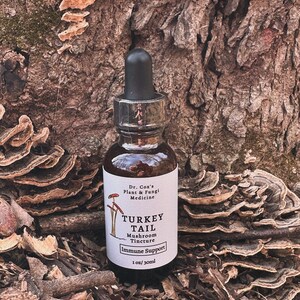 May include: A brown glass bottle with a black dropper top. The label reads "Dr. Cox's Plant & Fungi Medicine Turkey Tail Mushroom Tincture Immune Support 1 oz/30ml".