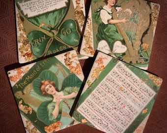May include: Four square coasters with a green, gold, and white color scheme. The coasters feature Irish-themed imagery, including shamrocks, a harp, and a woman in a green dress. The text on the coasters includes "Erin Go Bragh", "The Maid of Erin", and "Dear Irish".