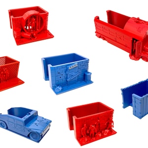 Könnte beinhalten: Ein Set aus 3D-gedruckten Miniaturgebäuden und -fahrzeugen, in Rot und Blau lackiert. Die Gebäude weisen eine Vielzahl von Details auf, darunter Fenster, Türen und Graffiti. Die Fahrzeuge umfassen einen Bus, ein Auto und einen LKW. Die Gebäude und Fahrzeuge sind für den Einsatz als Requisiten für Tischspiele oder als Dekorationsartikel konzipiert.