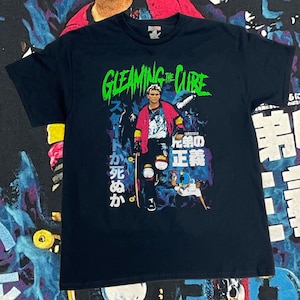 May include: Black t-shirt with a graphic print of a person skateboarding. The graphic includes the text "GLEAMING THE CUBE" in green and Japanese text.