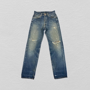 May include: Faded blue denim jeans with distressed details, including ripped knees and a button fly. The jeans have a classic five-pocket design and a straight leg fit. The denim has a worn appearance.