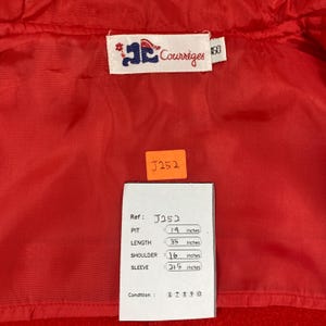 K&ouml;nnte beinhalten: Rote Jacke mit Courr&egrave;ges-Etikett. Die Ma&szlig;e der Jacke sind: Achsel 48 cm, L&auml;nge 89 cm, Schulter 41 cm und &Auml;rmel 55 cm. Ein Etikett mit der Referenznummer J252 ist ebenfalls sichtbar.