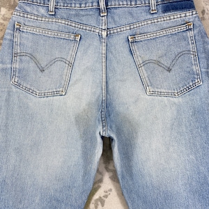 K&ouml;nnte beinhalten: Hellblaue Jeans mit zwei Ges&auml;&szlig;taschen und dem Levi's-Logo. Die Jeans haben eine verwaschene Optik und ein klassisches F&uuml;nf-Taschen-Design. Die R&uuml;ckseite der Jeans ist sichtbar und zeigt Bund und G&uuml;rtelschlaufen.