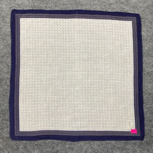 Peut inclure: Carré de mouchoir blanc avec un motif répétitif de petits cercles. Le mouchoir a une bordure bleu marine avec de fines rayures blanches et un bord bleu marine. Une petite étiquette rose est attachée au coin.
