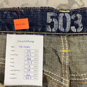 May include: Dark blue denim jeans featuring the number 503 printed in white on the waistband. A white tag displays measurements in inches: waist 33, front rise 10.5, hips 44, thigh 11.5, knee 9, leg opening 18, inseam 32, and outseam 42.5.