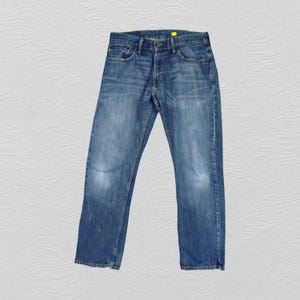 May include: A pair of blue denim jeans with a straight leg fit. The jeans have a light wash and are slightly faded.