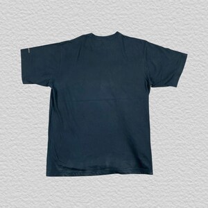 Pode incluir: Uma camiseta azul marinho escuro com mangas curtas. A camisa &eacute; lisa na frente e nas costas. A camiseta &eacute; feita de um material macio e confort&aacute;vel.