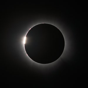 Peut inclure: Une éclipse solaire totale, avec la couronne du soleil visible comme un anneau brillant autour de la silhouette de la lune.