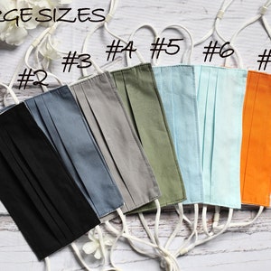 May include: Seven different colored face masks with white elastic straps. The masks are labeled with numbers 1 through 7. The text "LARGE SIZES" is at the top of the image.