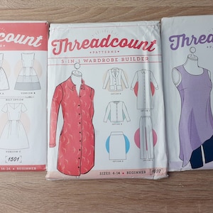 May include: Three sewing patterns from Threadcount. The first pattern is for a dress with three different versions. The second pattern is a 5-in-1 wardrobe builder. The third pattern is a studio collection.