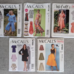 Puede incluir: Cinco sobres de patrones de costura McCall's. Los patrones presentan diseños de vestidos, faldas y tops. Los sobres muestran imágenes de las prendas terminadas e incluyen el logotipo de McCall's y los números de patrón.
