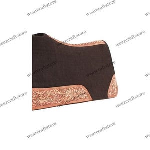 Puede incluir: Un salvacruces marr&oacute;n oscuro con un borde de cuero repujado. El ribete de cuero presenta un intrincado dise&ntilde;o floral en un color marr&oacute;n m&aacute;s claro. El salvacruces est&aacute; dise&ntilde;ado para uso ecuestre.