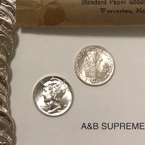 May include: Two silver US dimes, one with the profile of a woman and the year 1941, the other with the Statue of Liberty and the words "United States of America" and "One Dime".
