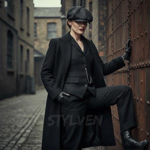 May include: A person in a black suit, coat, and cap, posing against a rusty metal wall. The outfit consists of a vest, trousers, and a long coat. The person is also wearing black gloves and boots. The word "STYLVEN" is visible on the lower part of the image.