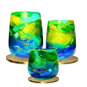 May include: Set of three glass vases with abstract blue, green, and yellow paint designs. The vases are on gold metal stands.