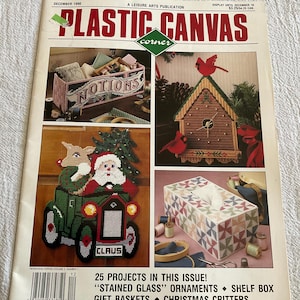 May include: A magazine cover titled "Plastic Canvas Corner" from December 1990, featuring various plastic canvas projects. The projects include a box labeled "Notions", a birdhouse with cardinals, a Santa Claus in a car, and a tissue box.