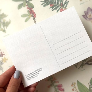 May include: A white postcard with black text. The text reads "Anna Sopeunenko. PEONY &copy; Акка Супруненко. ПИСМ annasoprusesk.com 2006 г. /бум, ак".