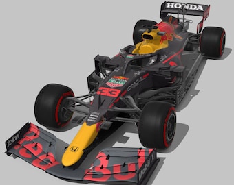 Può includere: Un'auto da corsa di Formula 1 nera e gialla con accenti rossi e neri. L'auto ha le parole "Honda", "Oracle", "Mobil 1" e "Red Bull" su di essa.