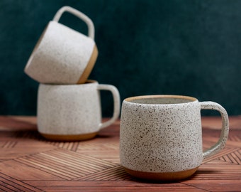 Taza de cerámica blanca hecha a mano en arcilla moteada