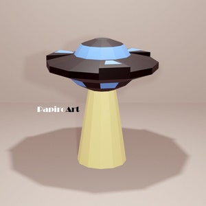 May include: A black and blue papercraft UFO with a yellow base. The UFO is hovering over a light brown surface. The text "PapirArt" is visible in the lower left corner of the image.