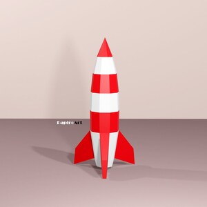 May include: A red and white striped rocket with a pointed nose and fins. The rocket is standing on a light brown surface.