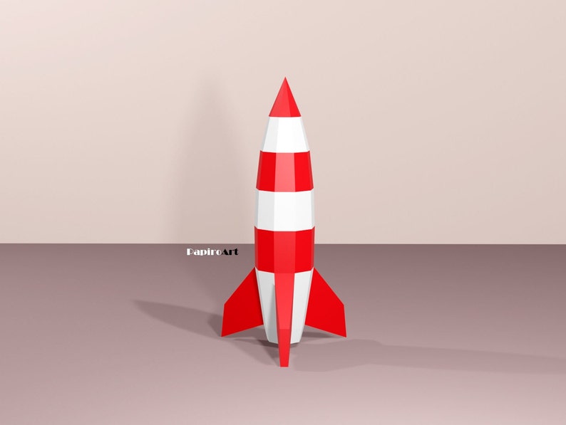 May include: A red and white striped rocket with a pointed nose and fins. The rocket is standing on a light brown surface.