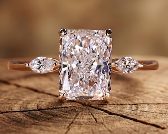Anillo de compromiso de tres piedras con diamante cultivado en laboratorio de talla radiante de 3,0 quilates, calidad E-VVS2, certificado por IGI. Anillo de oro amarillo de 18k con diamantes laterales de talla marquesa.