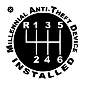 May include: A circular black and white decal featuring a manual transmission gear shift pattern with R, 1, 2, 3, 4, 5, and 6 positions. The text "MILLENNIAL ANTI-THEFT DEVICE INSTALLED" is printed in a circular border around the gear shift diagram.