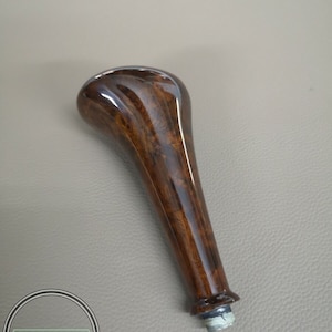 Puede incluir: Una palanca de cambios de madera marrón con un acabado brillante.