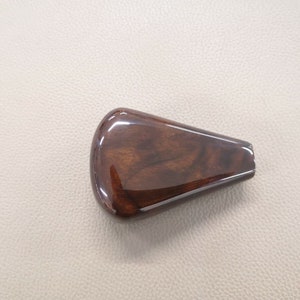 Puede incluir: Una palanca de cambios de madera marrón oscuro con un acabado brillante.