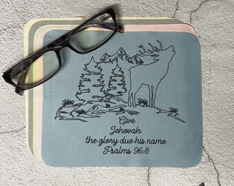 May include: A set of four square microfiber cleaning cloths in pastel colors, with a black-framed pair of eyeglasses resting on top. Each cloth features a mountain and deer design with the text "Give Jehovah the glory due his name Psalms 96:8."