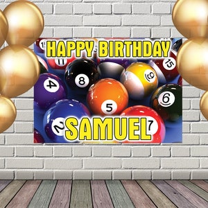 Op de afbeelding: Een kleurrijk verjaardagsbanner met een pooltafelthema. De banner heeft een blauwe achtergrond met biljartballen genummerd van 1 tot en met 15. De tekst "HAPPY BIRTHDAY SAMUEL" is gedrukt in gele letters.