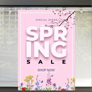 Pode incluir: Um cartaz rosa com as palavras "SPRING SALE" em letras brancas grandes. As palavras "SPECIAL OFFER" e "SHOP NOW" também são exibidas. O cartaz apresenta ilustrações florais e um ramo de flor de cerejeira.