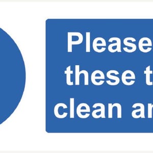 Può includere: Un cartello blu con testo bianco che dice: "Si prega di tenere questi servizi igienici puliti e in ordine". A sinistra, un cerchio blu con un punto esclamativo bianco.