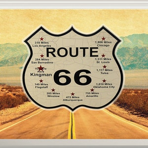 May include: A vintage-style Route 66 sign with a cracked, weathered surface. The sign is shaped like a shield and features the iconic Route 66 logo with the number 66 in large black font. The sign also includes the text "ROUTE" and lists various cities and distances along the route, including Los Angeles, Chicago, San Bernardino, Flagstaff, Winslow, Albuquerque, Amarillo, Oklahoma City, Tulsa, and St. Louis.